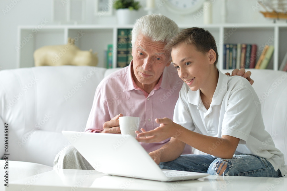 Boy and grandfather with a laptop at home Boy and grandfather with a laptop at home