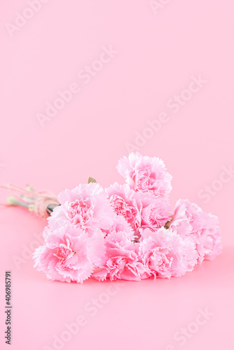 Fototapeta Naklejka Na Ścianę i Meble -  Mother's Day holiday gift design concept, pink carnation flower bouquet with greeting card, isolated on light pink background, copy space.