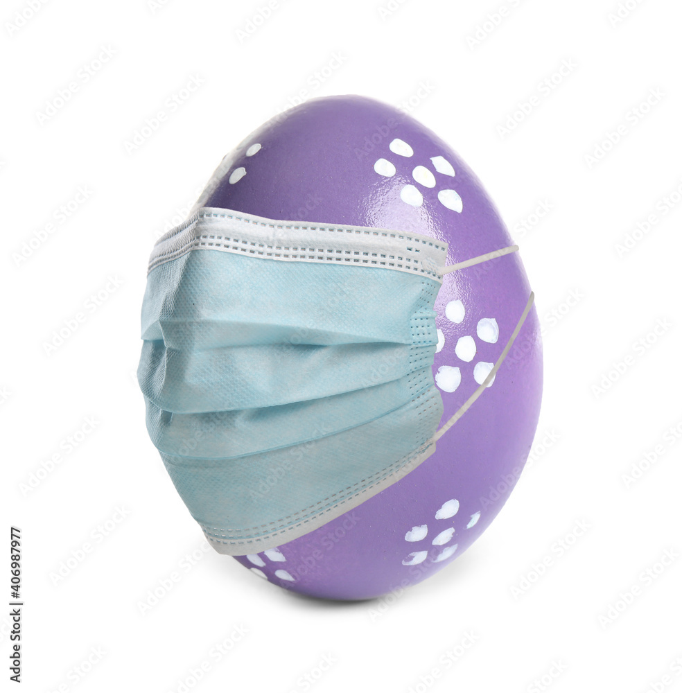 COVID-19 pandemic. Violet Easter egg in protective mask on white background COVID-19 pandemic. Violet Easter egg in protective mask on white background