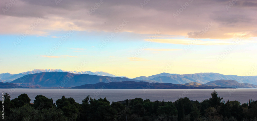 winter purple panoramic view of corfu island mountains of Albania and sea with cypress and olive trees