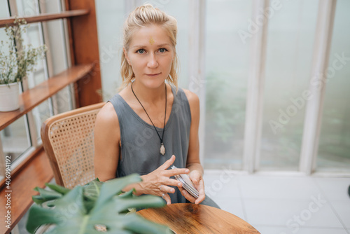 Woman is reading Tarot cards on a table in cafe photo