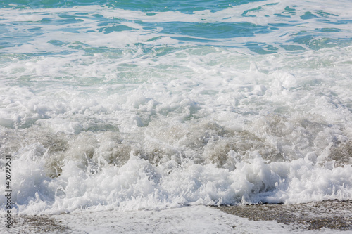 Blue sea water waves with white foam and bubbles. Winter see. Riva Trigoso on ligurian coast photo