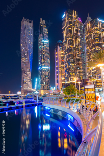 Night view to Dubai Marina panorama. Luxury skyscrapers and boats represent beautiful Dubai. Amazing colors reflect on the water. Shot at blue hour.