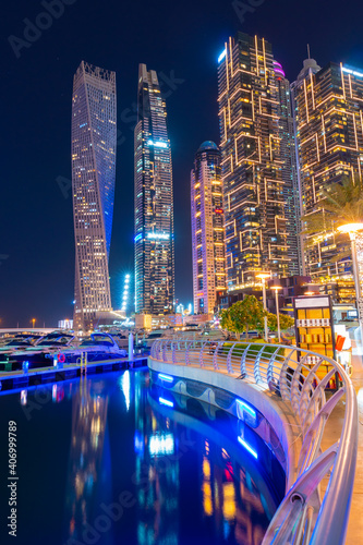 Night view to Dubai Marina panorama. Luxury skyscrapers and boats represent beautiful Dubai. Amazing colors reflect on the water. Shot at blue hour. photo