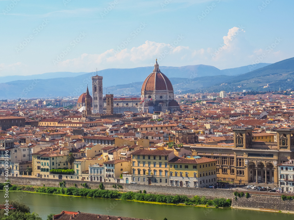 Beautiful cityscape of Florence. Famous Cathedral of Santa Maria del Fiore with red-tiled dome, marble facade and elegant Giotto Bell Tower in the center, National Library on the left side, Arno river