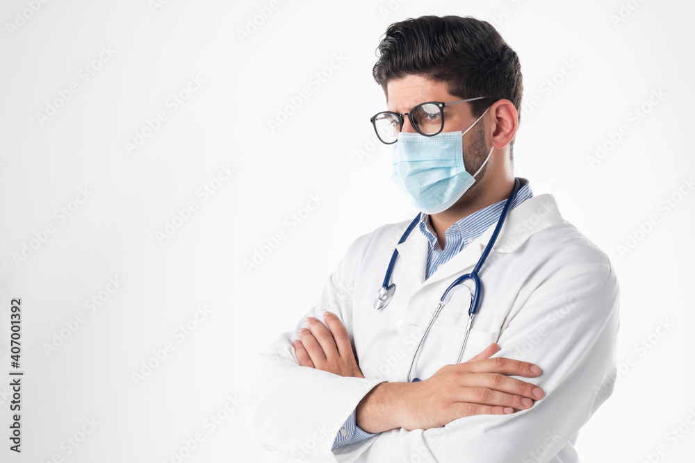 Studio portrait of male doctor wearing surgical mask while standing at isolated white background Studio portrait of male doctor wearing surgical mask while standing at isolated white background