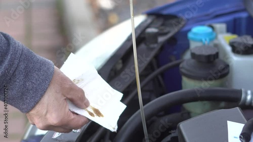 Inserting a dipstick to check the oil in a car