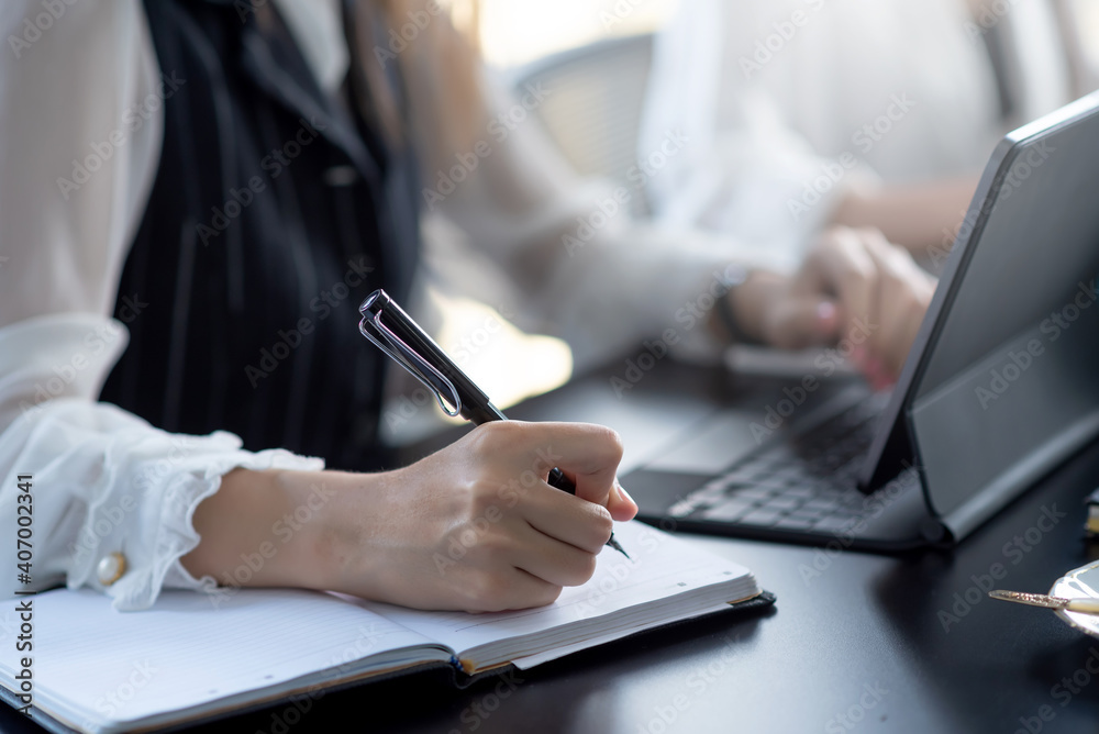 Businesswoman taking notes and working with laptop at office. Businesswoman taking notes and working with laptop at office.