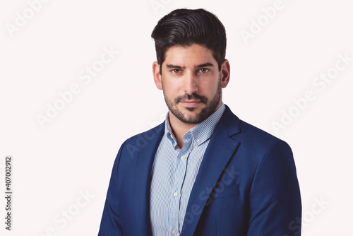 Confident businessman looking seriously while standing at isolated background