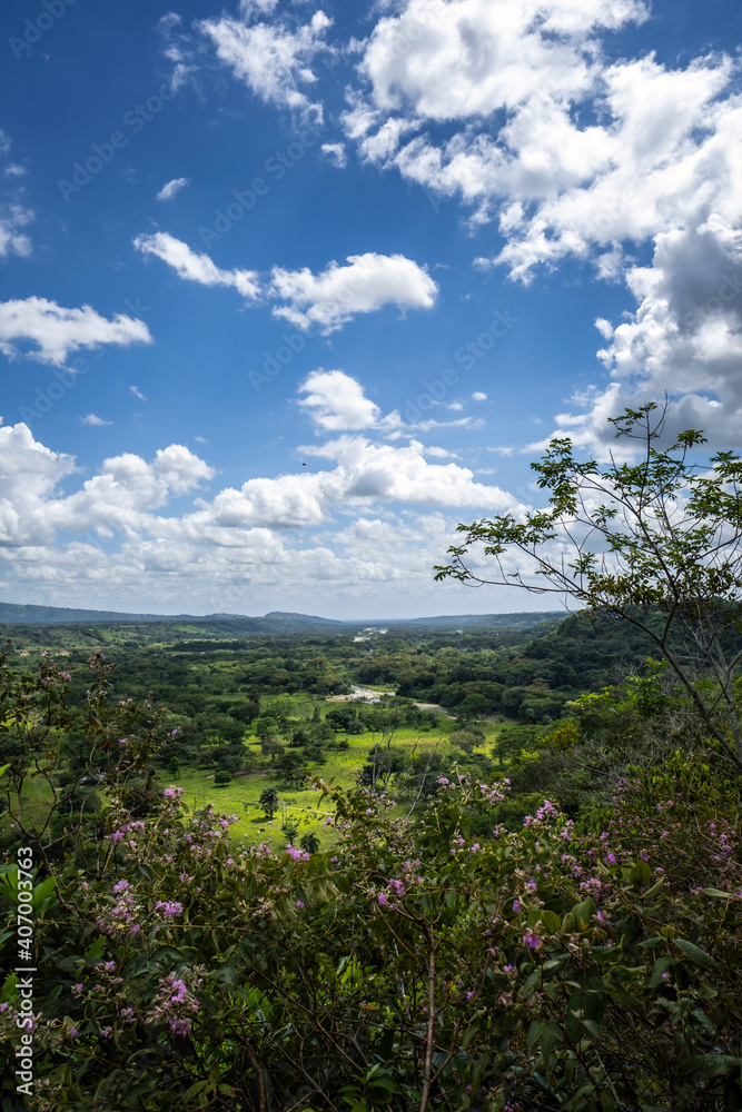 A valley in the Colombian mountains can be seen, the white clouds and the blue sky.