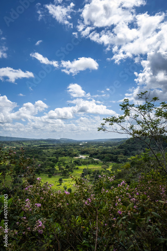 A valley in the Colombian mountains can be seen, the white clouds and the blue sky.