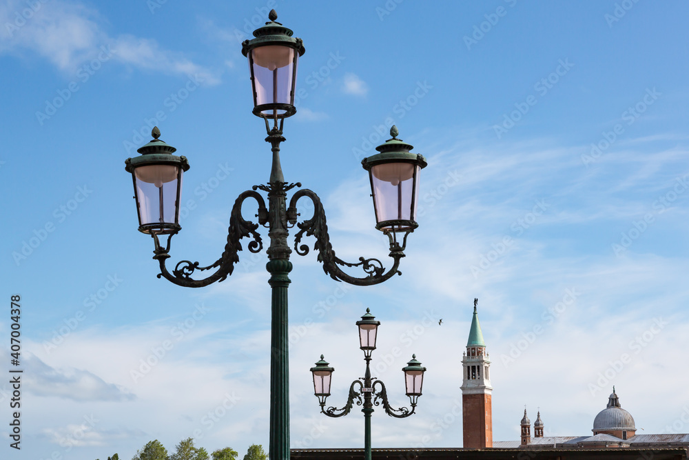 3-headed lanterns lining up towards Campanile tower of Venice, Italy