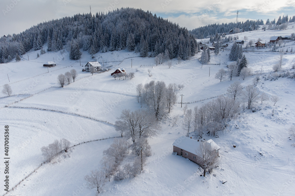 Winter frosty landscape of the beautiful Transylvanian village, Bran, with fresh snow, at the foot of the Carpathian Mountains