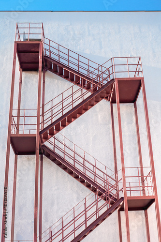 Exterior brown painted metal fire escape on the wall of a multi-storey building