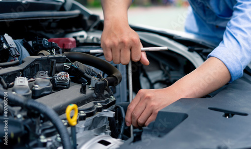 The male mechanic's hand holds the wrench In order to fix And check car engine, engineer concept and car repair