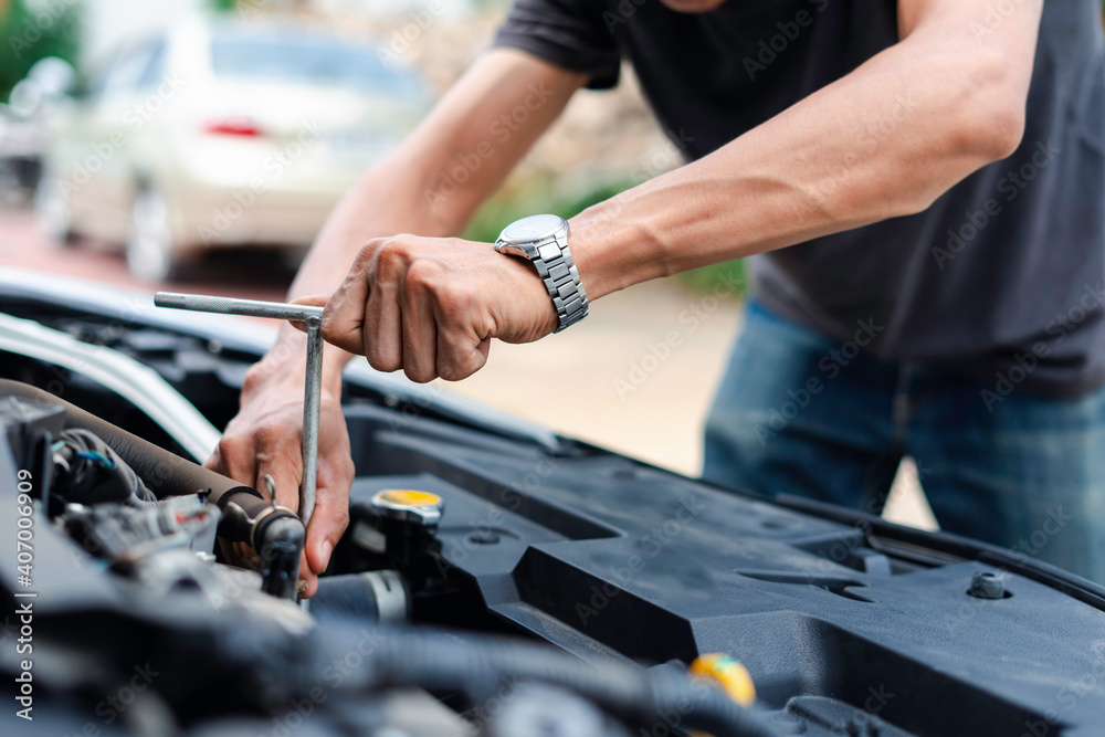 The male mechanic's hand holds the wrench In order to fix And check car engine, engineer concept and car repair