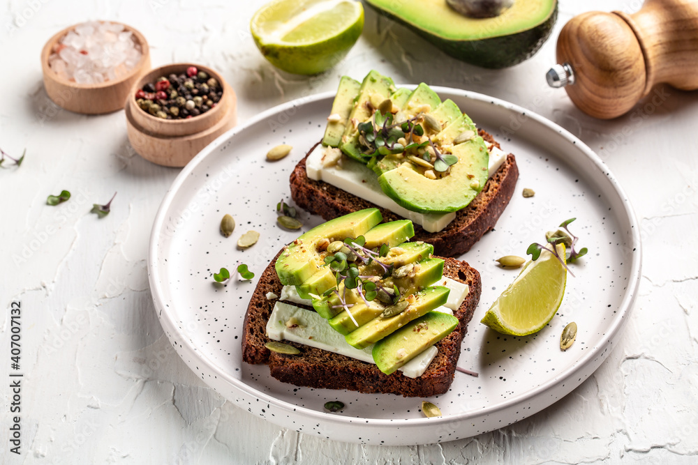 avocado toasts with rye bread, sliced avocado, pumpkin and sesame seeds, salt and pepper. Vegetarian sandwiches delicious breakfast or snack avocado toasts with rye bread, sliced avocado, pumpkin and sesame seeds, salt and pepper. Vegetarian sandwiches delicious breakfast or snack