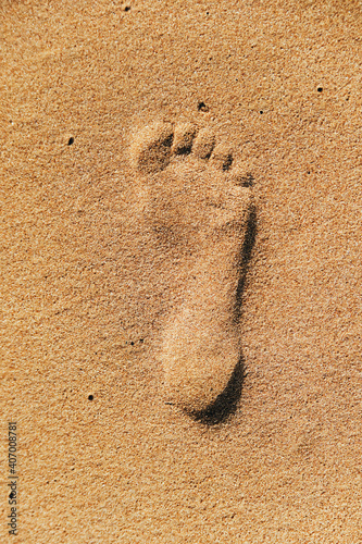 Footprint of one foot on wet sand by the sea