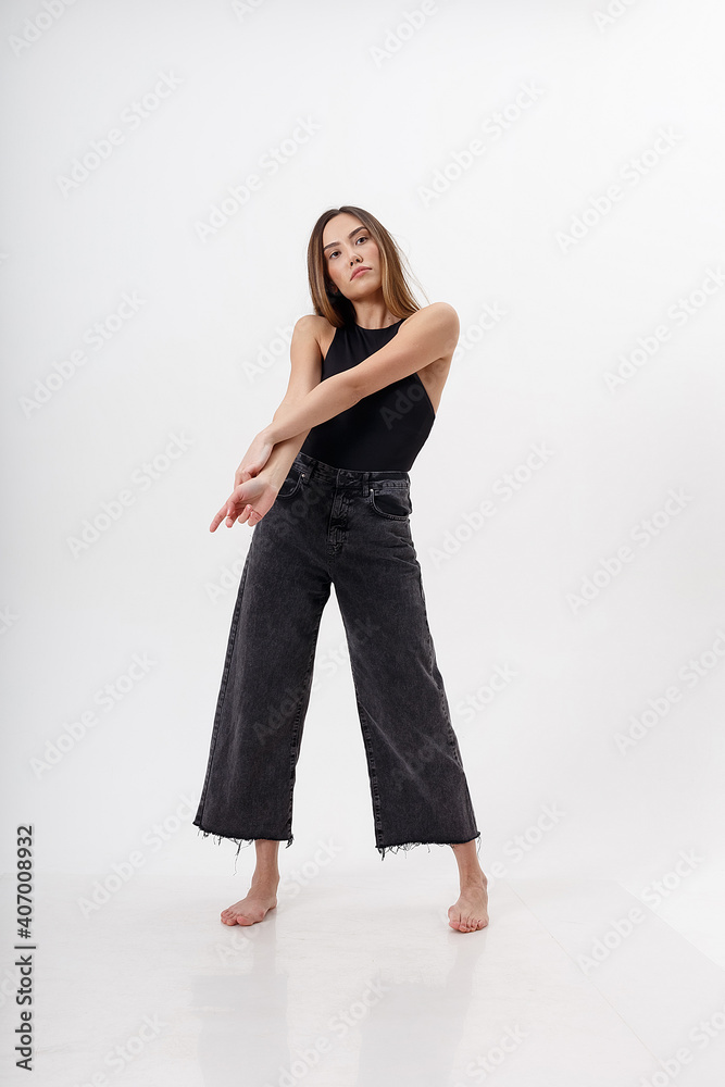 portrait of young attractive asian woman with long hair in black bodysuit, jeans, isolated on white studio background. skinny pretty female posing on cyclorama. model tests of beautiful lady portrait of young attractive asian woman with long hair in black bodysuit, jeans, isolated on white studio background. skinny pretty female posing on cyclorama. model tests of beautiful lady