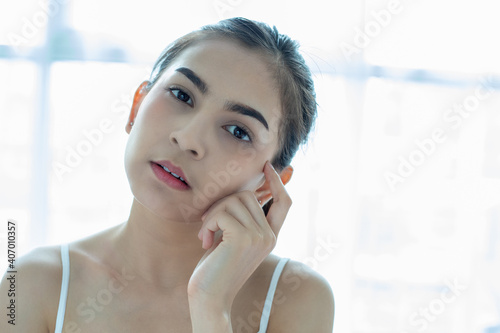 Free Download A beautiful woman asian using a skin care product, moisturizer or lotion taking care of her dry complexion. Moisturizing cream in female hands . - GFXLoad