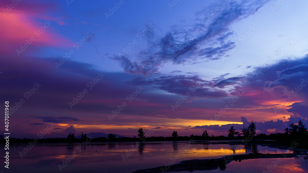 Dusk sky with colorful sunset on sundown in the evening over lake landscape