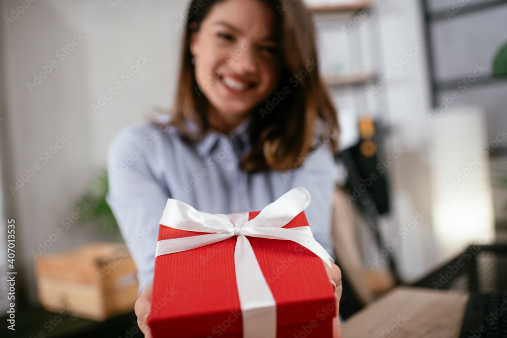 Portrait of a cheerful young businesswoman with gift. Happy businesswoman holding gift box Portrait of a cheerful young businesswoman with gift. Happy businesswoman holding gift box