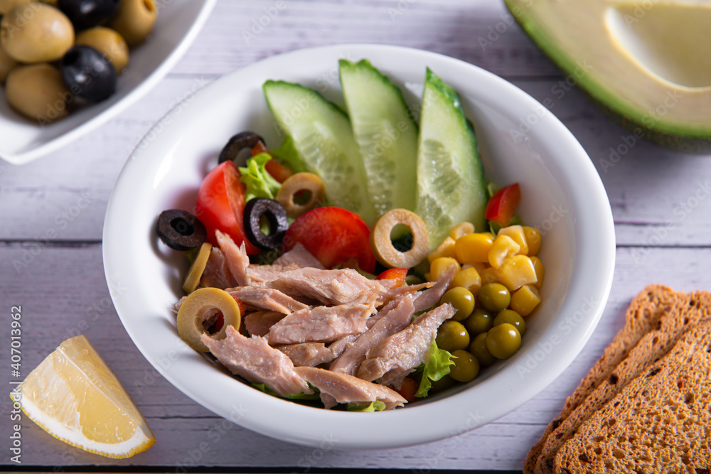 canned tuna salad with fresh vegetables in white plate top view