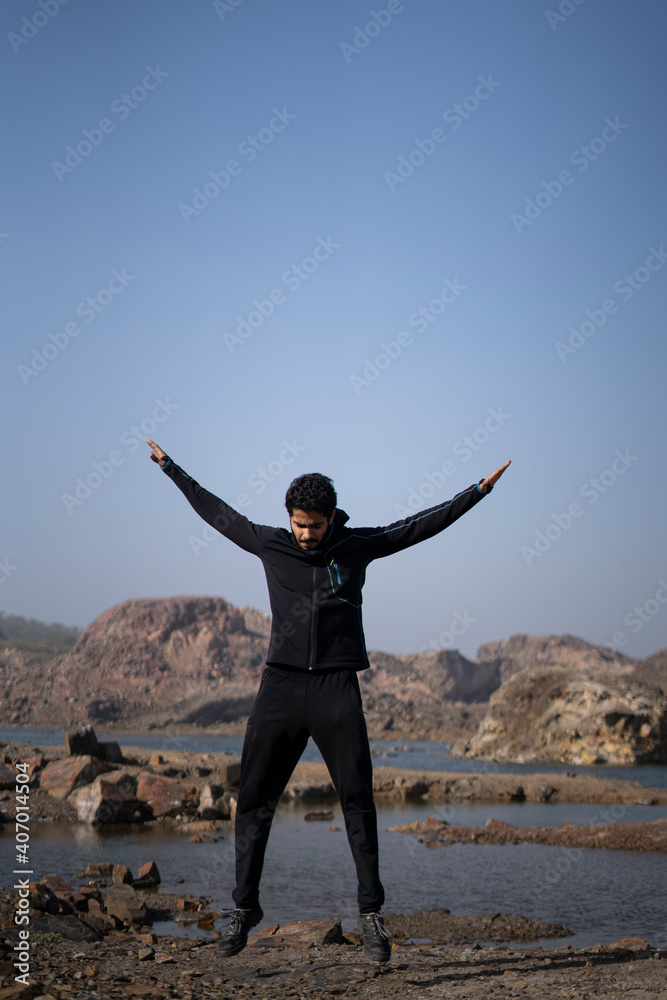 young athletic man doing burpee near a lake surrounded with mountains early in the morning, wearing track suit. Healthy lifestyle concept. young athletic man doing burpee near a lake surrounded with mountains early in the morning, wearing track suit. Healthy lifestyle concept.