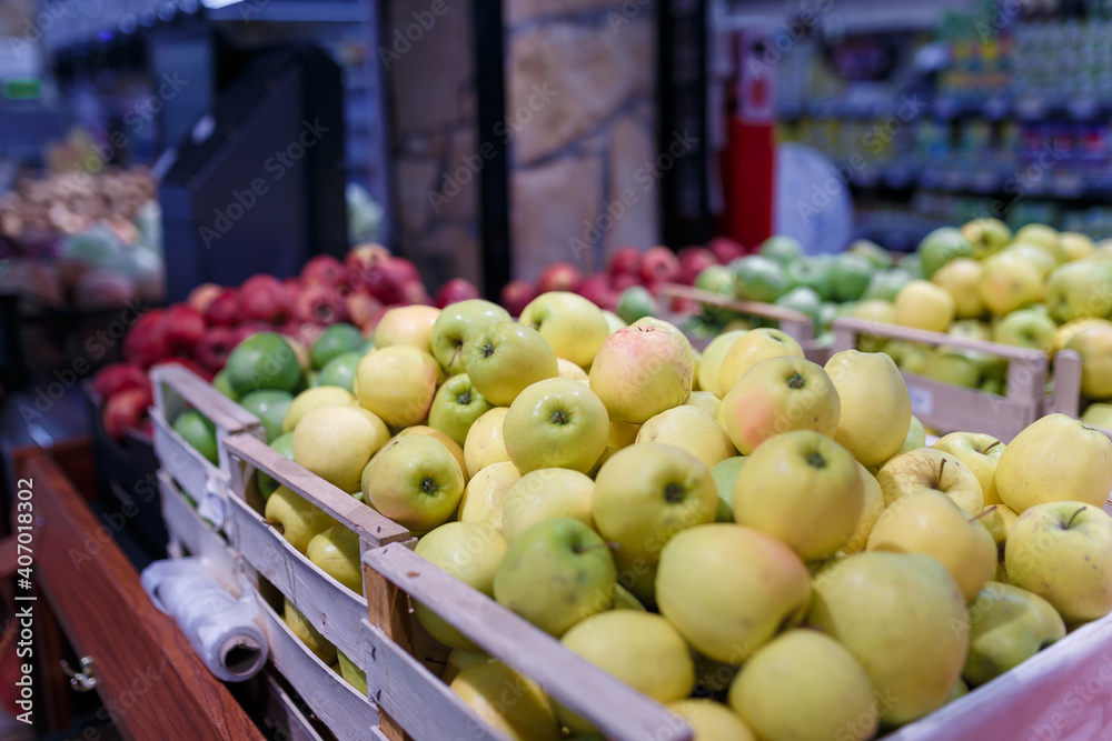 Soft focused shot of fruit department in grocery store, supermarket, mall, hypermarket or shopping center. Red, yellow and green apples in boxes. Healthy eating, avitaminosis concept. Soft focused shot of fruit department in grocery store, supermarket, mall, hypermarket or shopping center. Red, yellow and green apples in boxes. Healthy eating, avitaminosis concept.