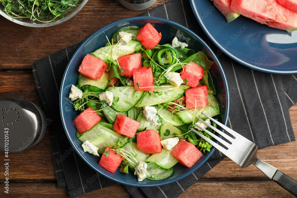 Delicious salad with watermelon served on wooden table, flat lay