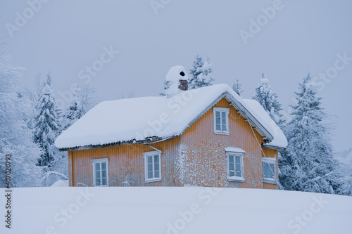 Abandoned yellow house in the snow.