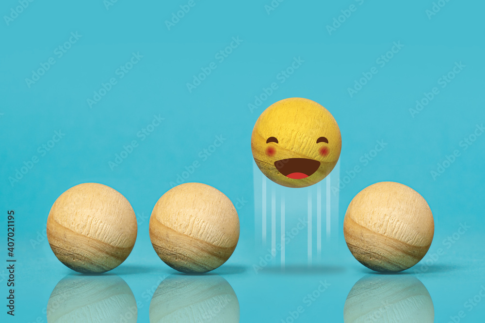 Wooden balls like emoticons. Concept of happiness. Blue background

