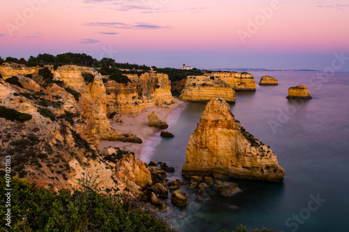 Scenic sunset view of Praia (English Beach) da Marinha and the nearby cliffs and the Atlantic Ocean near Lagos in the Algarve in Portugal. Soft focus, long exposure, low light