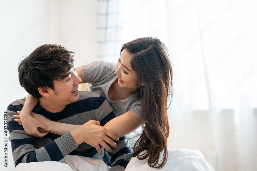 wonderful young asian couple on bed in bedroom hug and enjoy life together and smiling tender couple hugging in bed in the morning with happiness wonderful young asian couple on bed in bedroom hug and enjoy life together and smiling tender couple hugging in bed in the morning with happiness