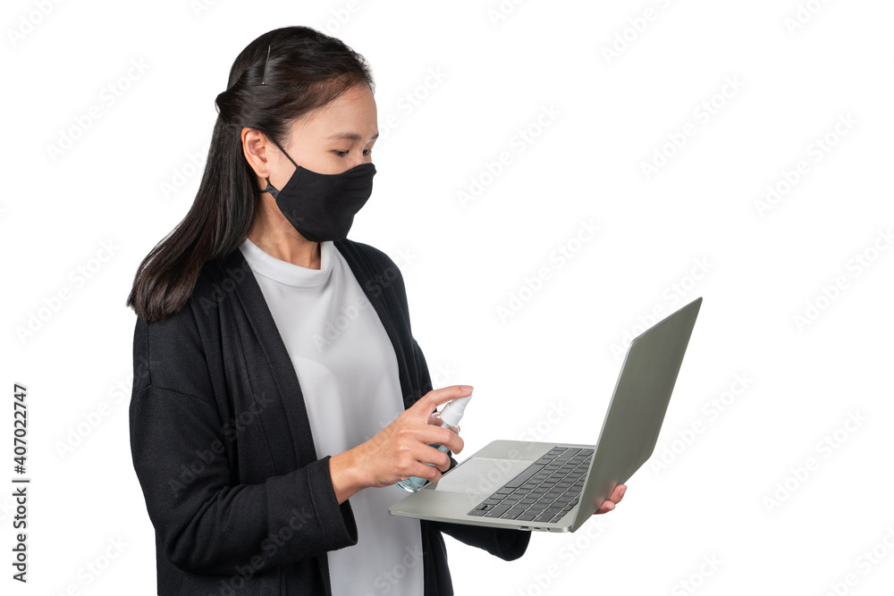 Asian woman cleaning the surface of the computer notebook keyboard and monitor. Woman holding Alcohol sanitizer spray bottle for cleaning anti bacteria virus. Asian woman cleaning the surface of the computer notebook keyboard and monitor. Woman holding Alcohol sanitizer spray bottle for cleaning anti bacteria virus.
