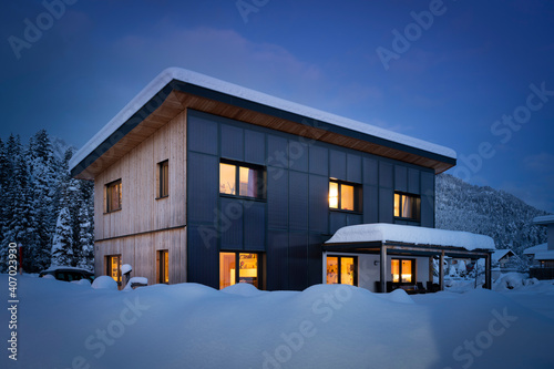 heat energy self-sufficient single-family house in the snow-covered winter with solar thermal collectors on the facade