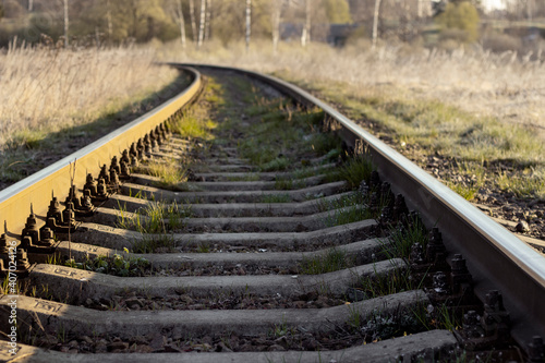 The railway goes into the distance, beyond the horizon. The railway passes through wildlife. Railway, sleepers and rails in close examination. Sleepers and rails passing through wildlife.