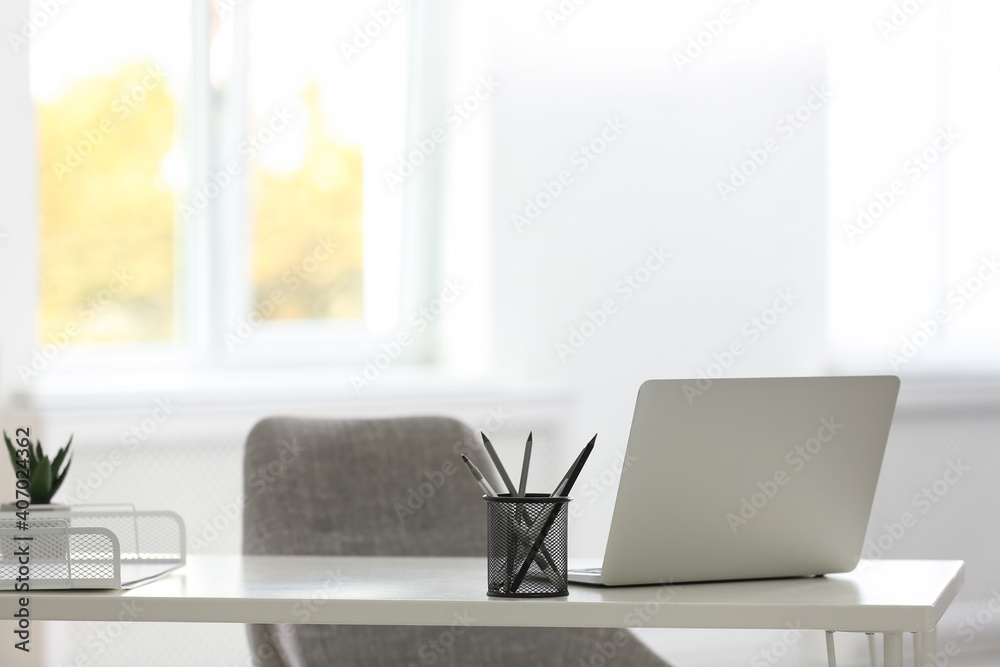 Laptop and stationery on white table in office. Modern workplace Laptop and stationery on white table in office. Modern workplace