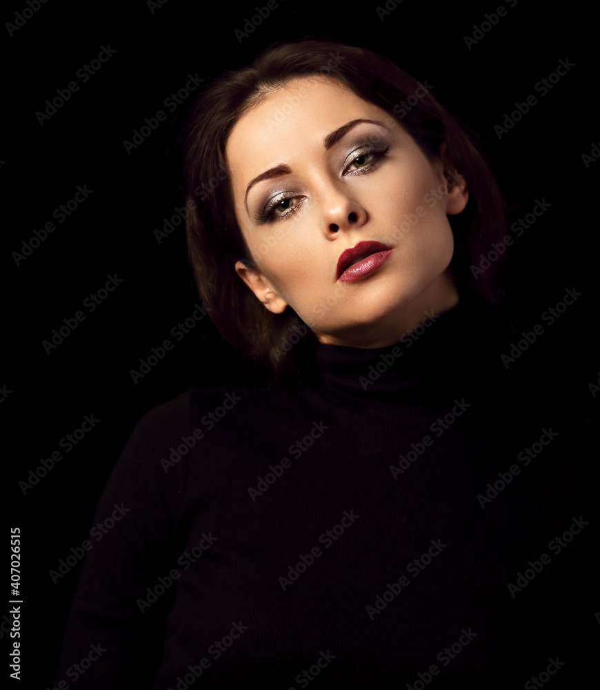 Sexy woman with bright evening makeup, red lipstick brown brow posing isolated on dark black background. Closeup portrait in deep low key light shadows. Art. Sexy woman with bright evening makeup, red lipstick brown brow posing isolated on dark black background. Closeup portrait in deep low key light shadows. Art.