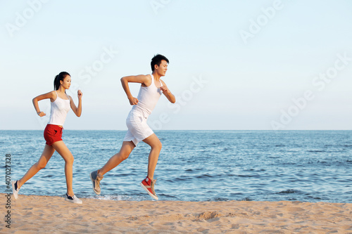 Portrait of young Couple running on beach