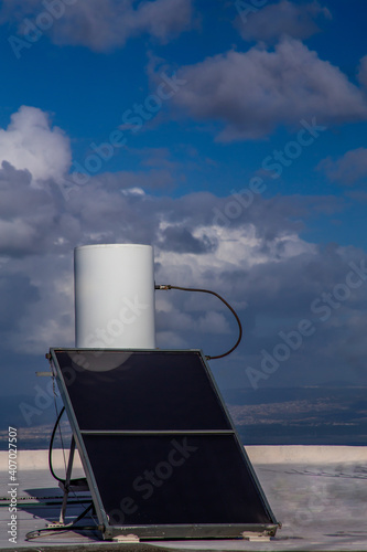 solar rooftop boiler on a sunny day against the background of the sky with clouds