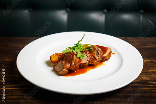 Juicy piece of grilled meat with fried potatoes and arugula