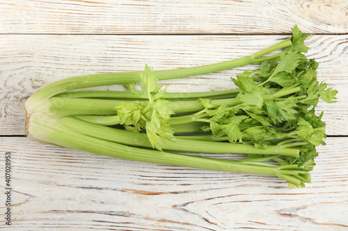 Fresh ripe green celery on white wooden table, top view