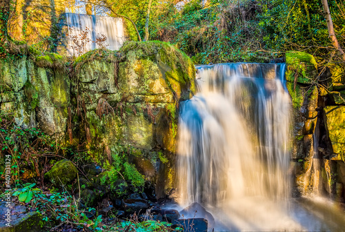 A long exposure view a pair of cascading waterfalls at Lumsdale on Bentley Brook, Derbyshire, UK