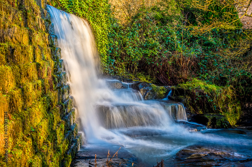 Fototapeta Naklejka Na Ścianę i Meble -  A long exposure side view of a waterfall at Lumsdale on Bentley Brook, Derbyshire, UK