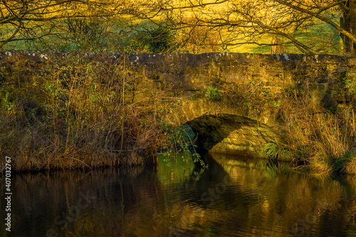 A view of a stone arched bridge over Bentley Brook, Derbyshire, UK