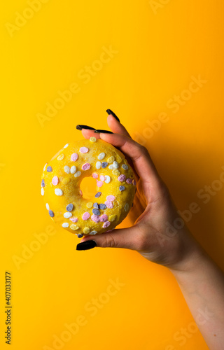 yellow background, donut in the hand, girl