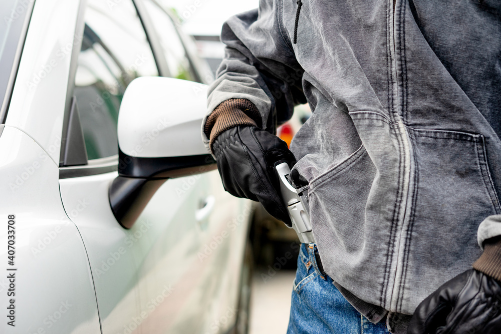 custom made wallpaper toronto digitalA robber dressed in black pointing a gun at a driver in a car. Car thief concept.