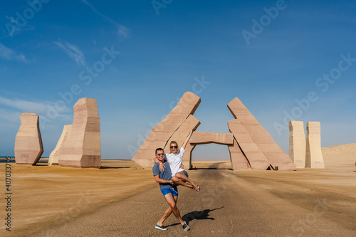 Couple jump near huge Gate of Allah, Ras Mohammed national park in Egypt. Desert
