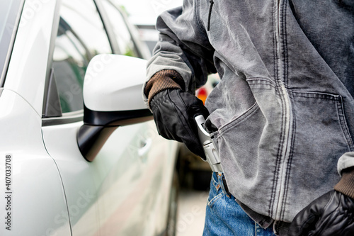 Wallpaper Mural A robber dressed in black pointing a gun at a driver in a car. Car thief concept. Torontodigital.ca
